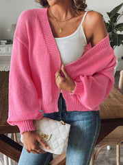 Strawberry pink balloon sleeve knit cardigan with V-neck and ribbed cuffs.