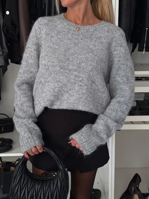Gray acrylic knit sweater with crew neck and ribbed cuffs, styled with black shorts.