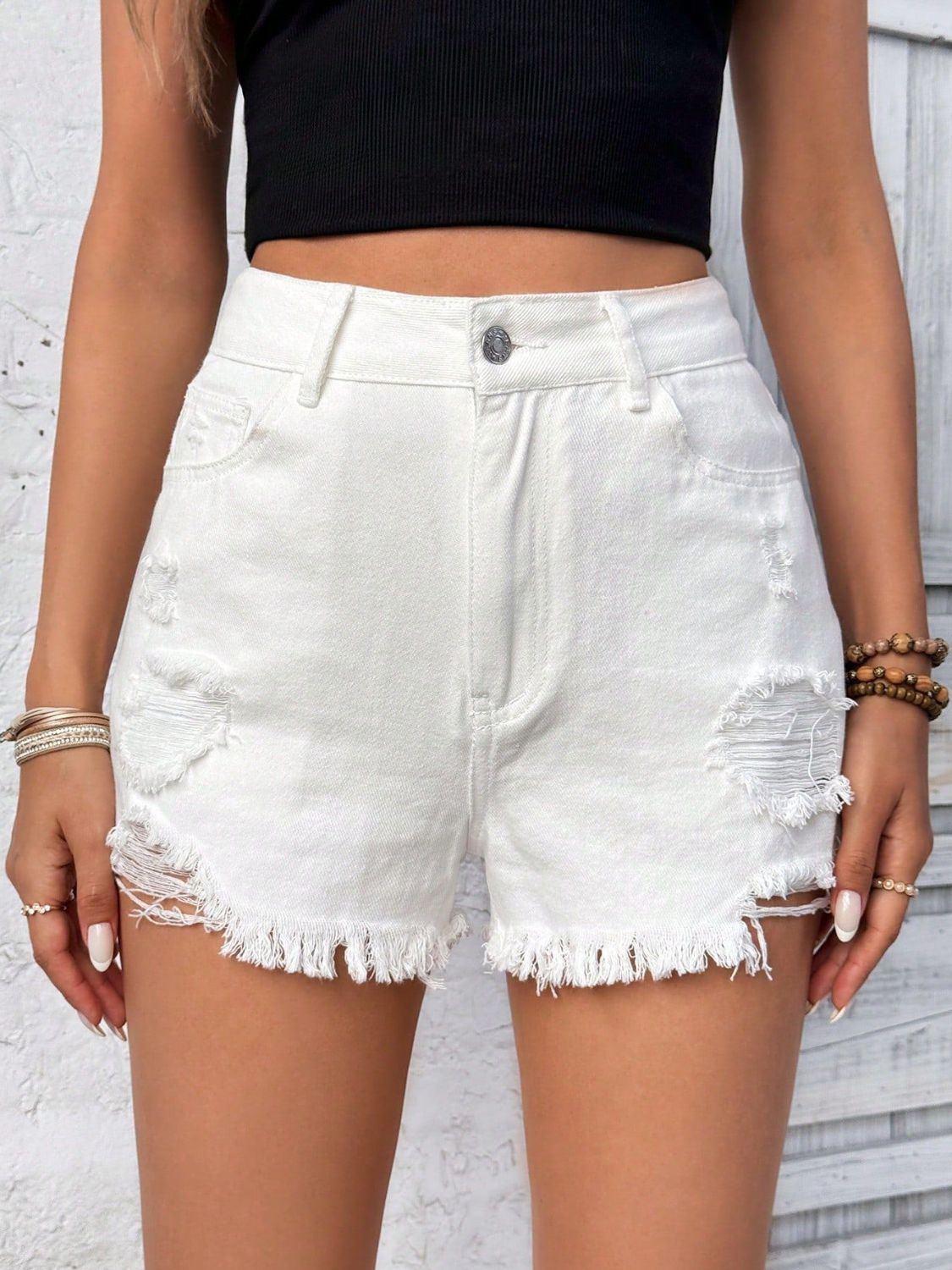 White denim shorts with distressed details and frayed hem