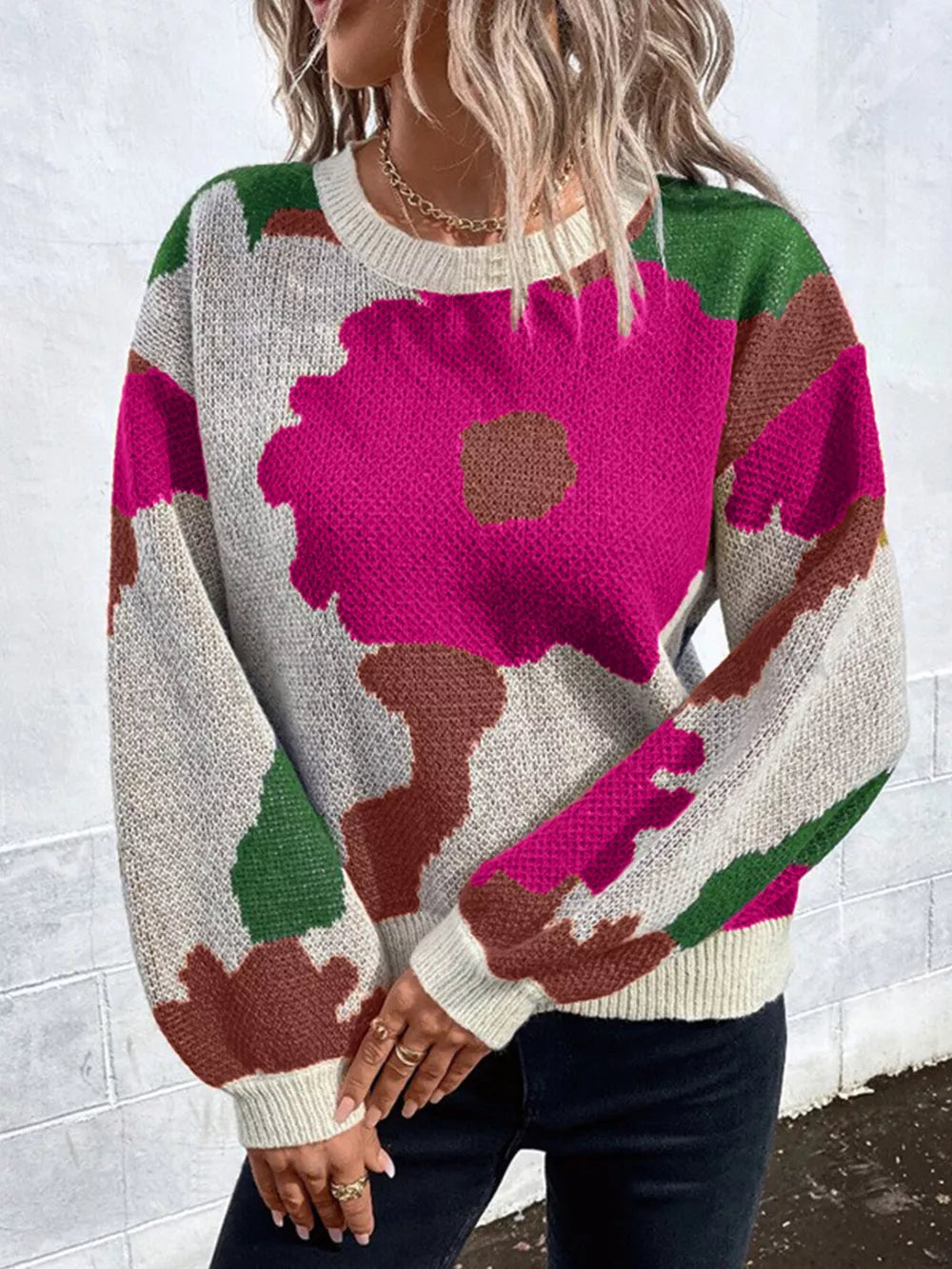 Abstract floral knit sweater with round neck in pink, green, brown, and cream.
