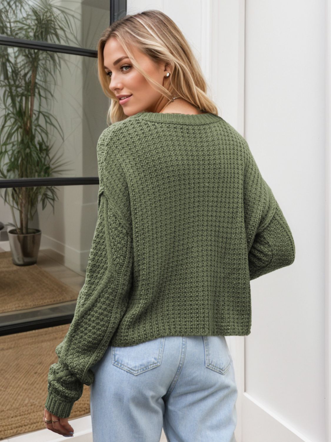 Moss green acrylic cable knit cropped sweater with textured stitch detail.