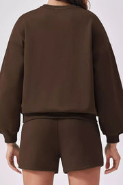 Cozy two-piece sweatshirt set in dark brown, featuring balloon sleeves and comfortable shorts.