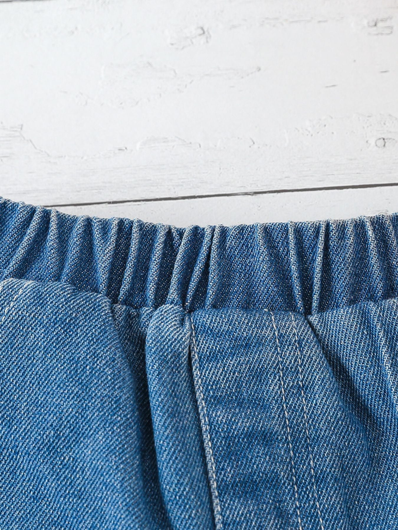 Blue denim shorts with elastic waistband and white stitching detail