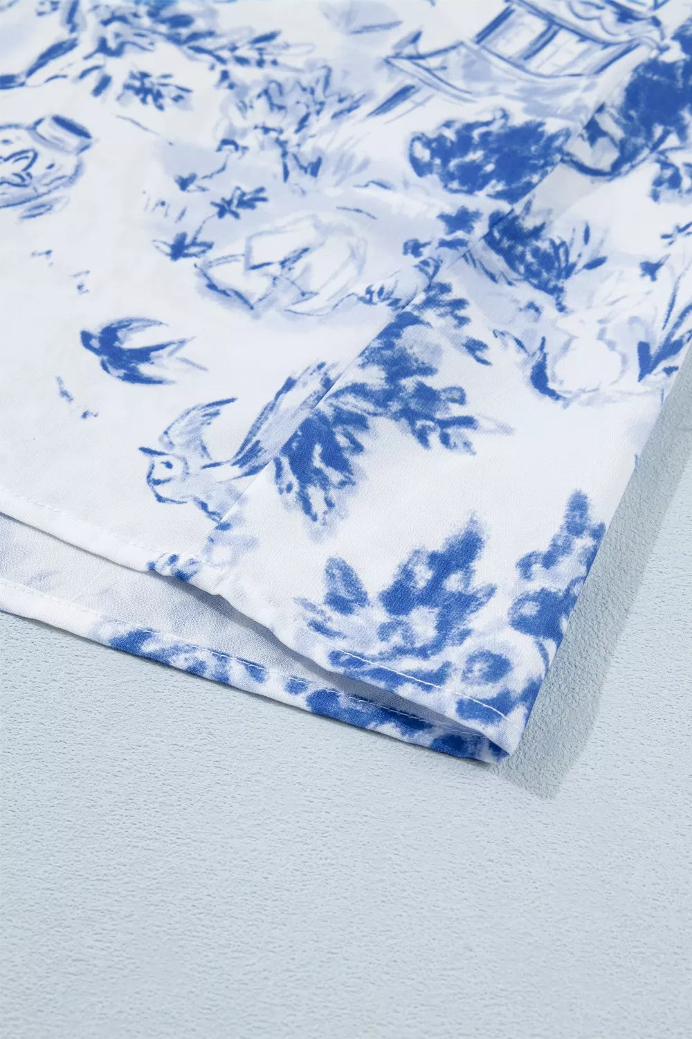 White polyester shirt with blue toile print and birds.
