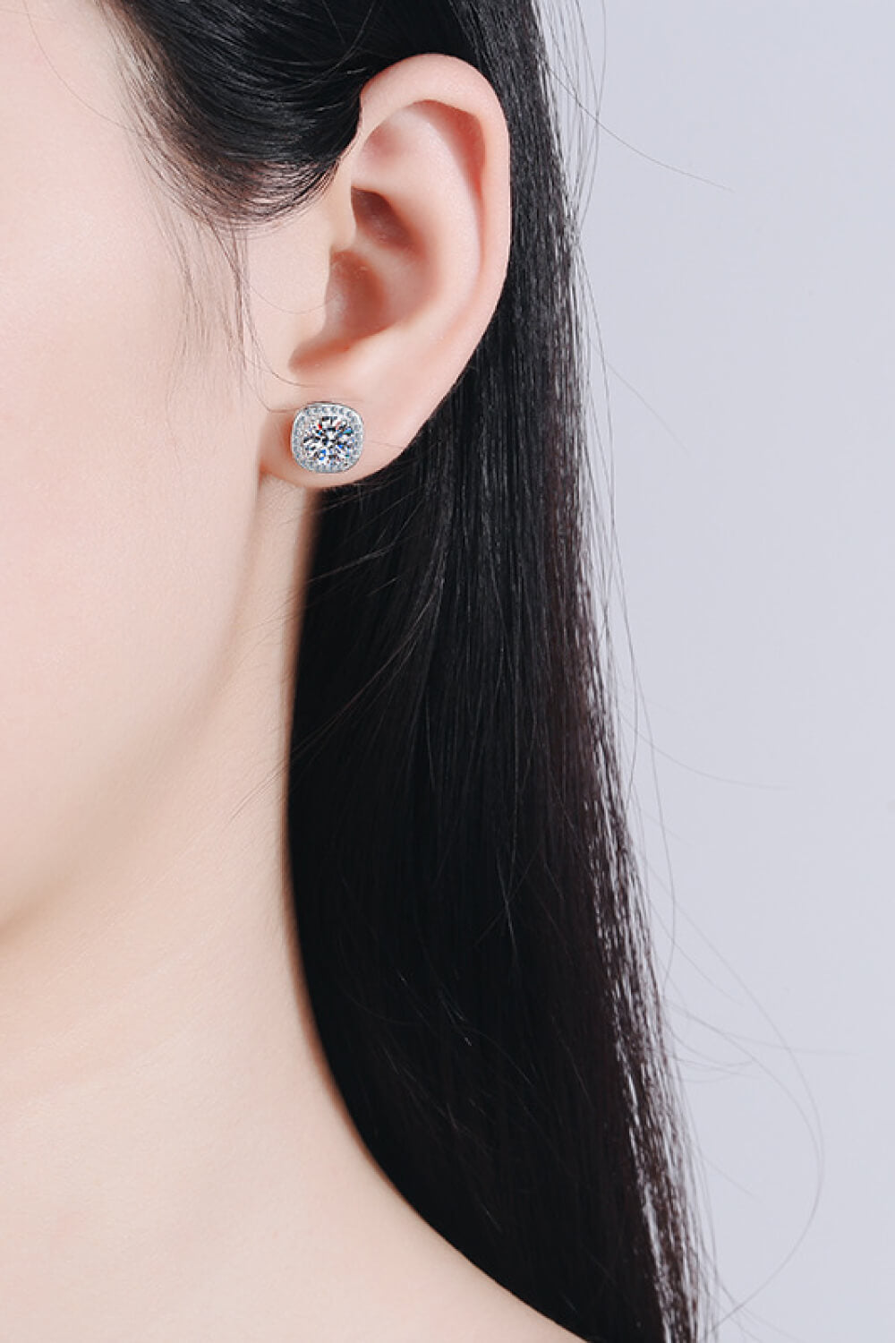 Silver cushion cut halo moissanite stud earrings with a square halo setting.