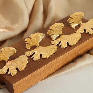 Gold Ginkgo leaf statement earrings with textured fan shape.