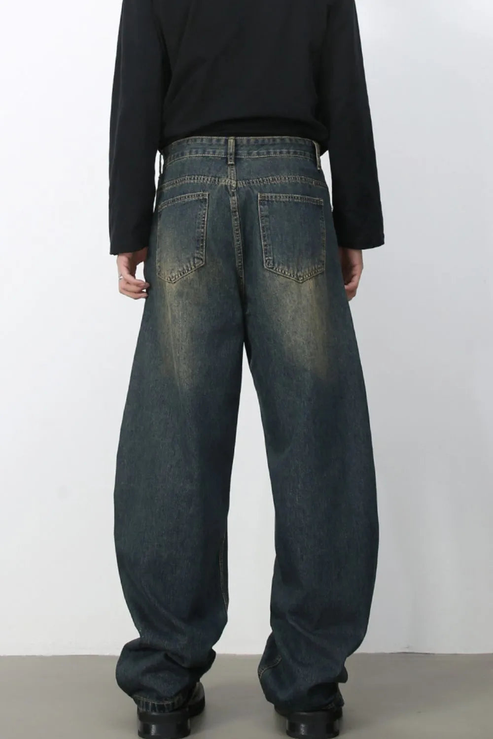 Faded baggy denim jeans in a dark blue wash with a relaxed fit.