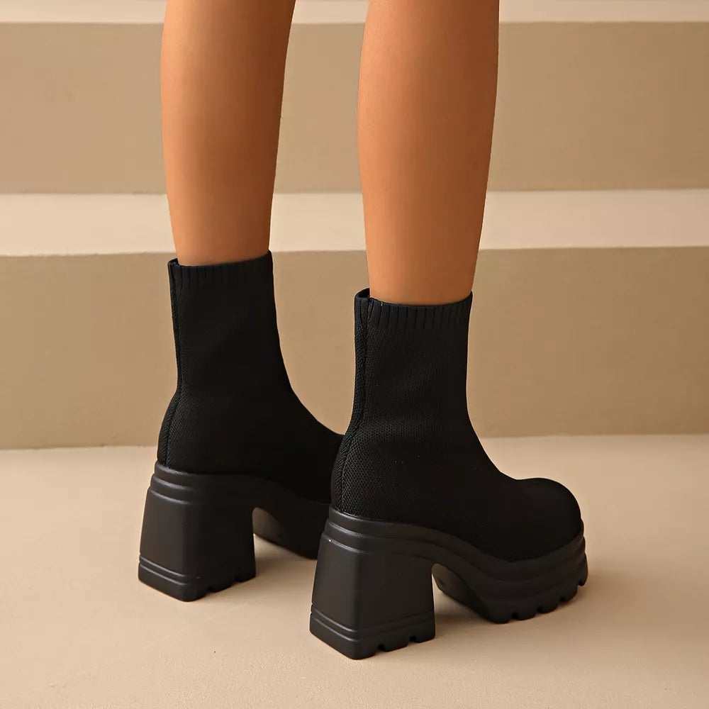 Black sock ankle boots with round toe and chunky platform heel.