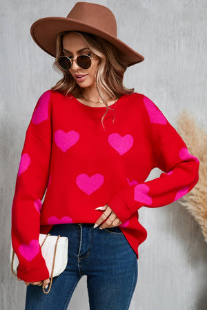 Red acrylic knit sweater with pink intarsia hearts, crew neck, long sleeves.