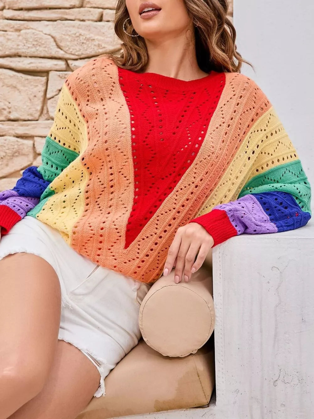 Vibrant color-blocked openwork knit sweater with rainbow stripes and a V-neck detail.