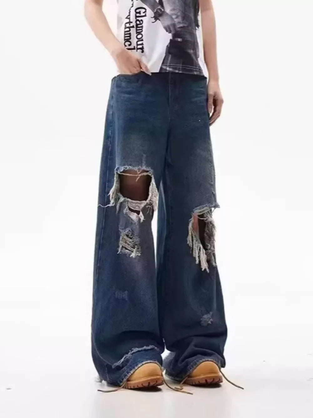 Men's distressed wide-leg jeans in dark wash denim with large rips.