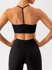 Black ribbed halterneck active bra with Y-back straps and adjustable detail.