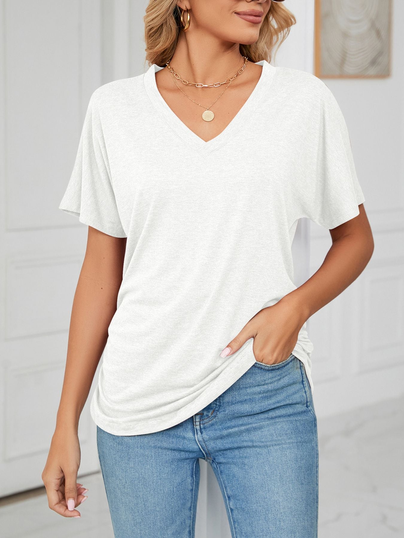 Relaxed white v-neck short sleeve t-shirt with draping detail.