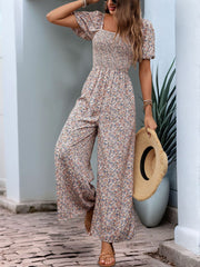 Floral smocked bodice wide leg jumpsuit with puff sleeves and a square neckline.
