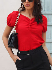 Red ruched button-front puff sleeve blouse with a textured fabric.