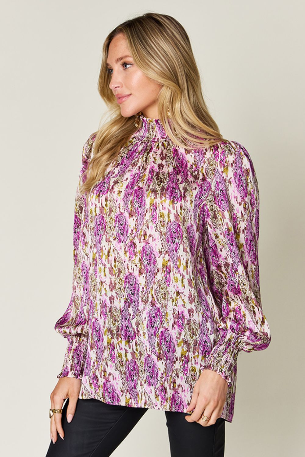 High neck abstract print blouse in red-violet with long sleeves and smocked cuffs.