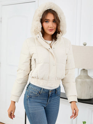 Cream puffer jacket with faux fur trim hood, cinched waist, and zip pockets.