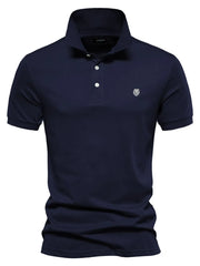 Navy cotton polo shirt with embroidered crest detail and button placket.