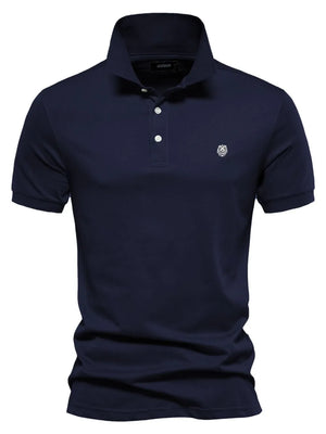 Navy cotton polo shirt with embroidered crest detail and button placket.