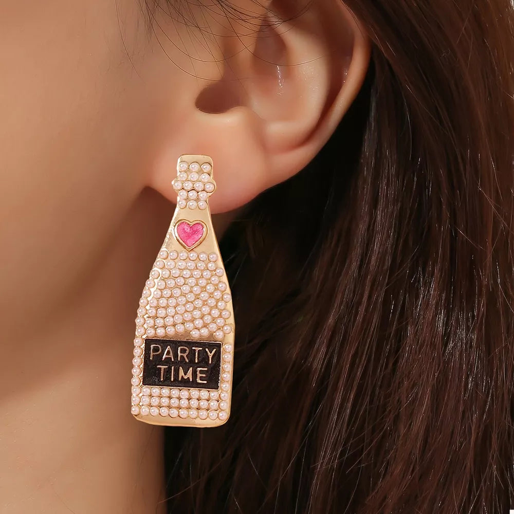 Champagne bottle drop earrings with pearls, pink heart, and PARTY TIME label.