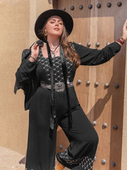 Black viscose palazzo jumpsuit with square neck and embroidered details.
