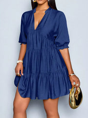 Navy blue tiered mini dress with notched V-neck and puff sleeves.