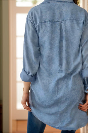 Light blue oversized denim shirt jacket with buttoned cuffs and a back pleat detail.