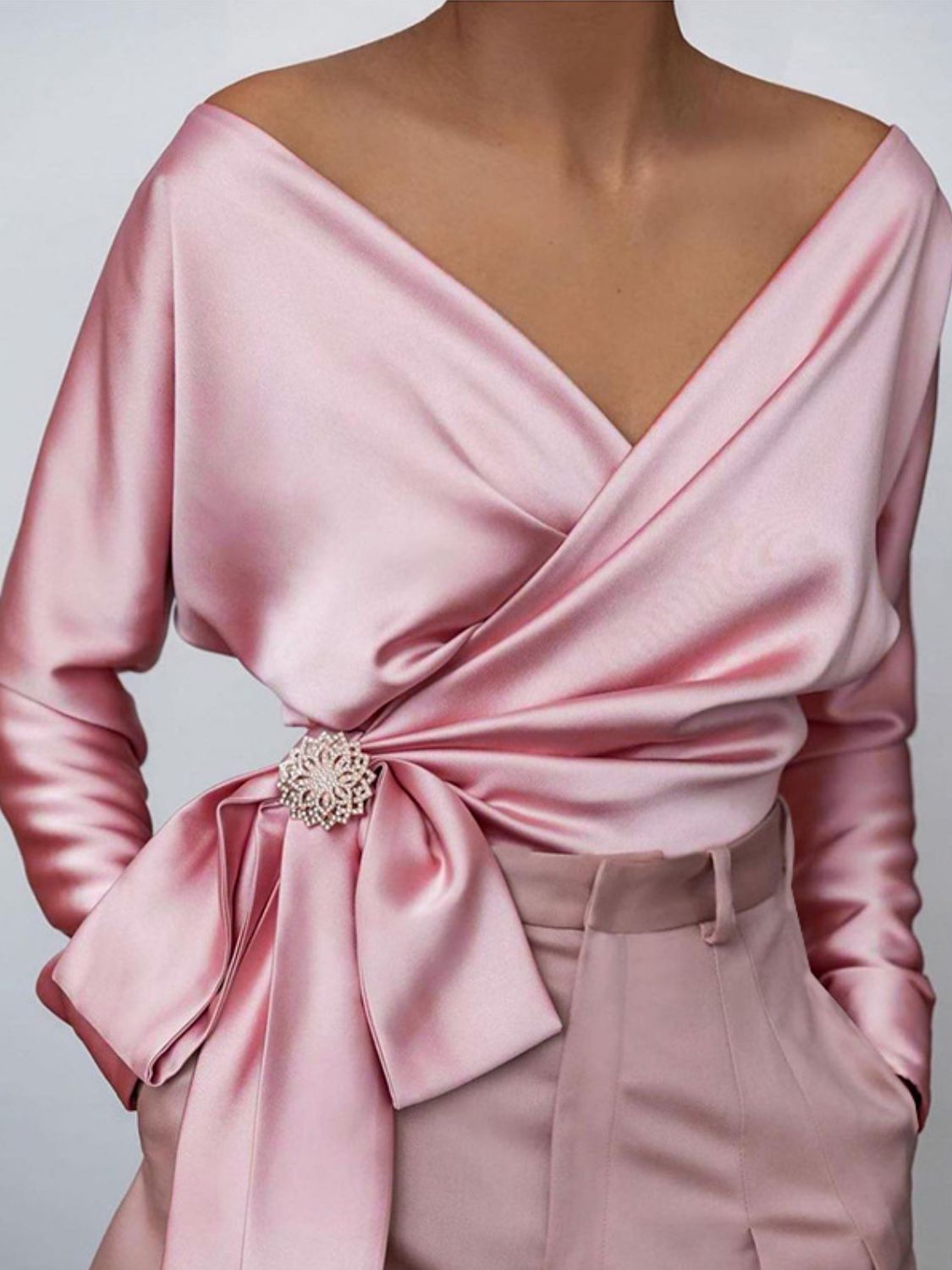 Blush pink satin blouse with brooch detail and draped neckline