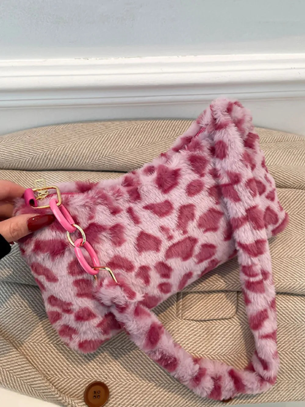 Fuchsia pink leopard print faux fur shoulder bag with chain detail.