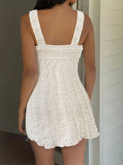 Ruched sweetheart neck mini dress in beige with textured fabric and elastic straps.