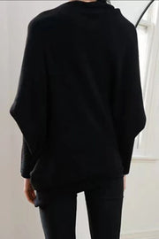 Black off-shoulder knit sweater with textured cuffs and batwing sleeves.