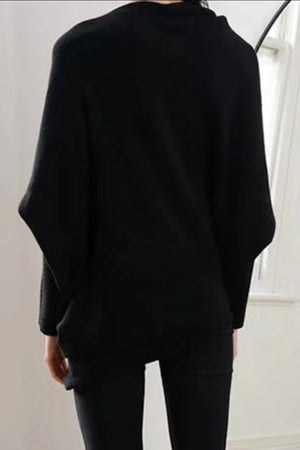 Black off-shoulder knit sweater with textured cuffs and batwing sleeves.