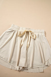 Beige ruffled skort with tie waist detail and elastic waistband.