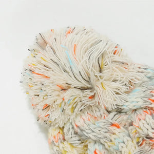 Textured knit pom beanie with colorful flecks and cable detail.