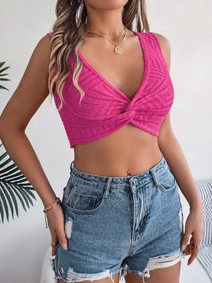 Hot pink knit crop top with twisted front detail and deep V-neck.