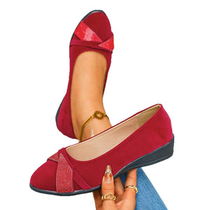 Red slip-on wedge flats with rhinestone-adorned bow detail and ankle bracelet.