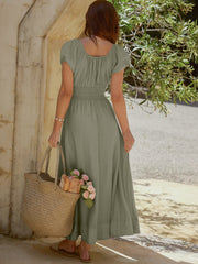 Sage green smocked waist maxi dress with short puff sleeves and a square neckline.