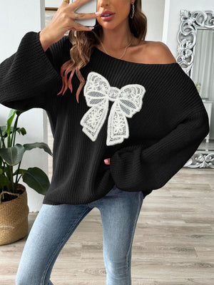 Black off-shoulder knit sweater with a white lace bow embellishment and balloon sleeves.