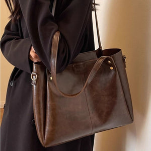 Large distressed brown leather shoulder bag with detachable strap and gold hardware.
