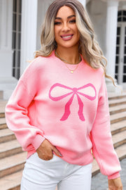 Blush pink acrylic sweater with a graphic bow intarsia pattern and crew neckline.