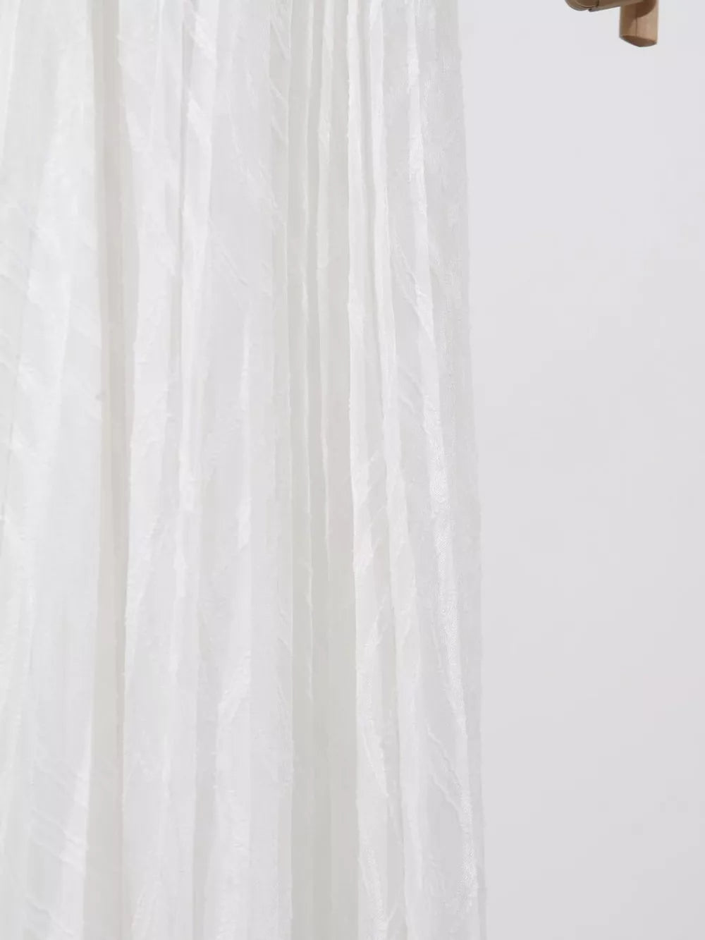 White maxi dress with textured vertical stripes and flowing fabric detail