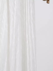 White maxi dress with textured vertical stripes and flowing fabric detail