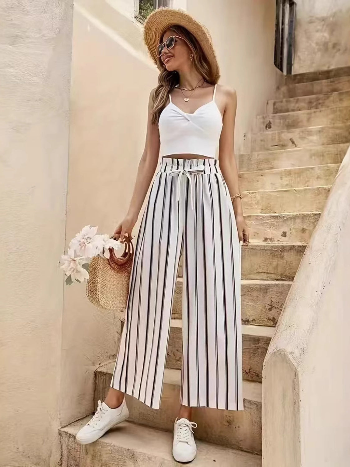 High-waisted palazzo pants with black and white vertical stripes and a drawstring waist.