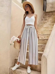 High-waisted palazzo pants with black and white vertical stripes and a drawstring waist.