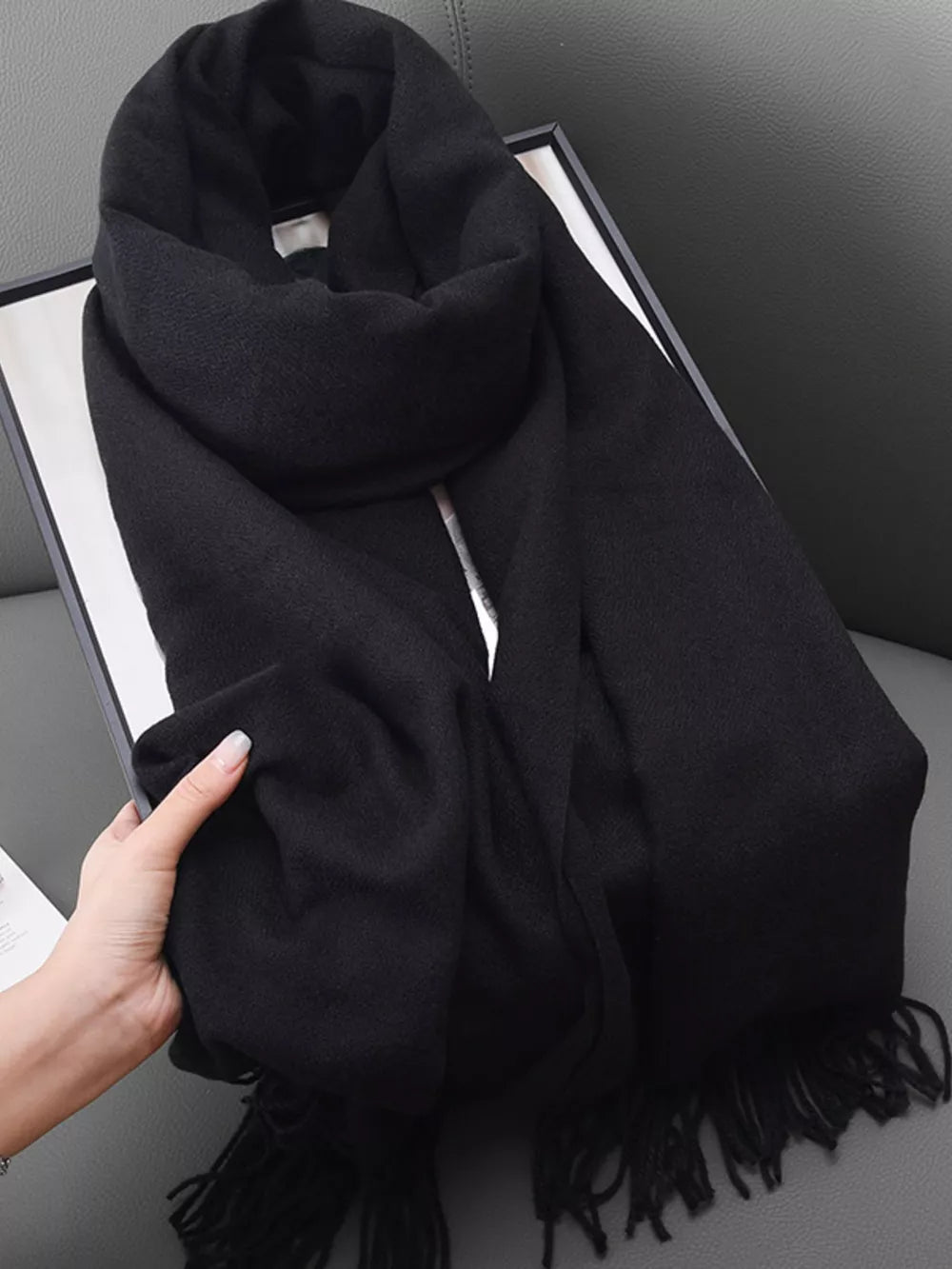 Black fringe scarf with soft texture and elegant drape.