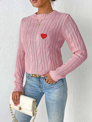 Dusty pink cable knit sweater with embroidered red heart detail.