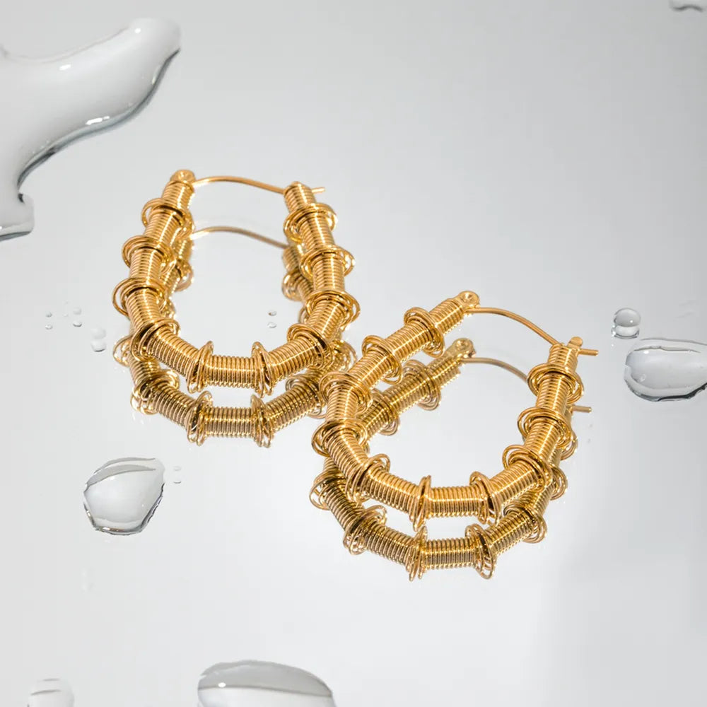 Gold coiled wire hoop earrings with a textured, layered design.