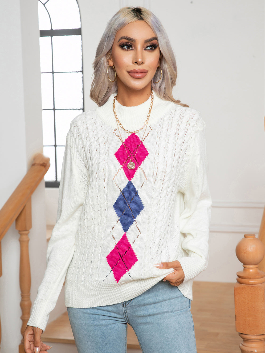 White argyle cable-knit mock neck sweater with pink and blue diamonds.