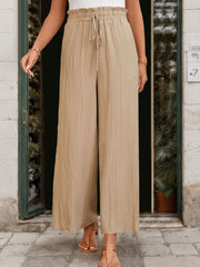 Tan textured wide-leg drawstring trousers with a ruffled elastic waistband.