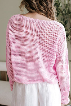 Openwork floral intarsia sweater in blush pink acrylic with a boat neck.